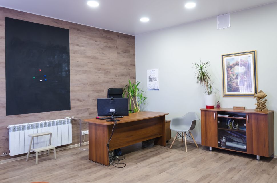 Фотография кабинета 32 кв.м , рабочие столы, пвх плитка, радиатор, грифельная доска, компьютер, серые стулья, элементы декора